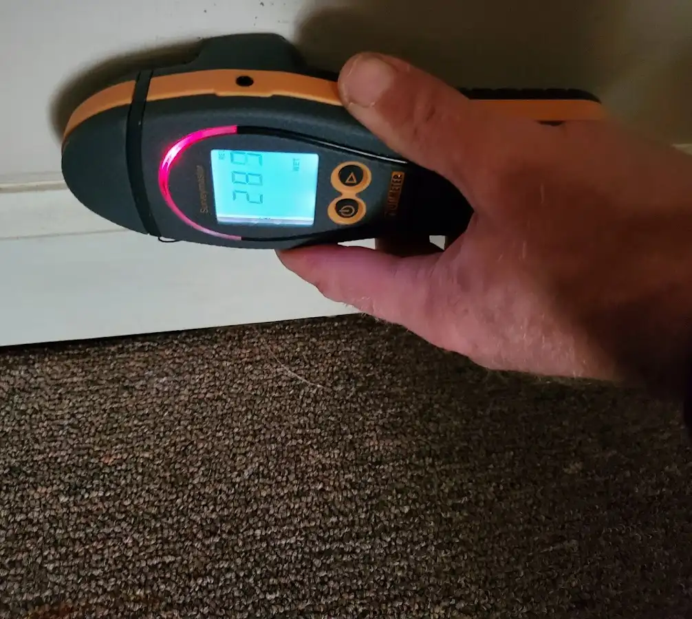 Moisture detection at baseboard during Storm Damage Restoration in Spring